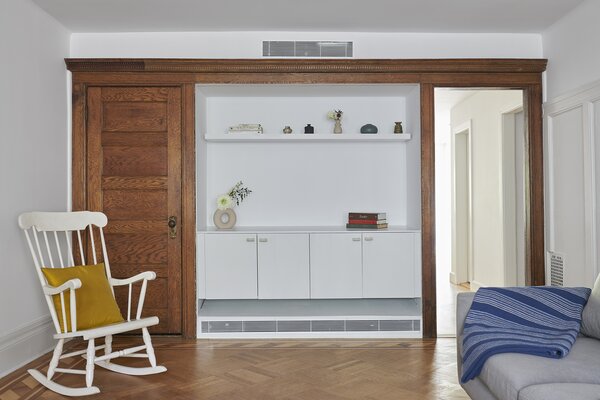 A dilapidated built-in had to be removed, and Lee swapped in a floating storage unit and shelf in its place, wrapped in the original wood casework for contrast.