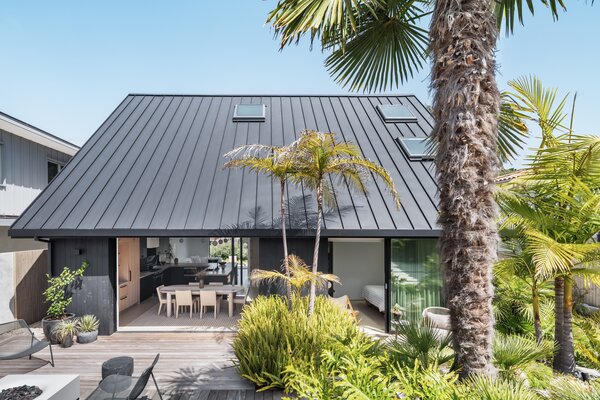 A massive gable roof draping the first floor makes this two-story house feel more like one.