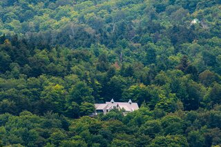 Although there are several houses nearby, the homeowners relish the privacy and tranquility provided by the surrounding dense forest. 