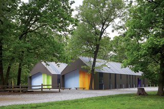 The two-tone corrugated metal cladding helps the sheds blend into the landscape, along with windows custom-colored by the manufacturer to match.