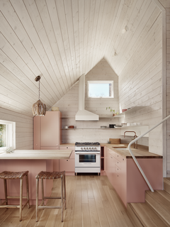 The angle of the custom range hood creates, in negative space, the same trapezoidal shape as the exterior. Cabinets are IKEA with custom-painted fronts. 